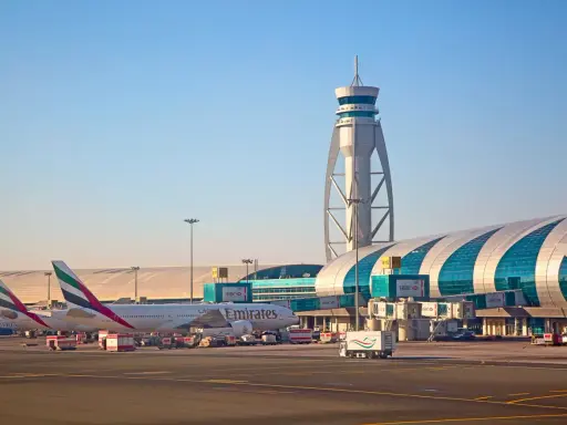 Emiraty Arabskie linie lotnicze na lotnisku w Dubaju. Samoloty Emirates, wieża kontroli lotów i nowoczesny terminal.
