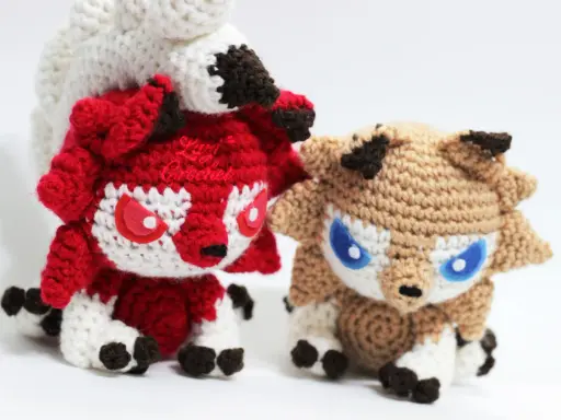 Dos adorables pokémon amigurumi, uno rojo y otro marrón, listos para la aventura. ¡Encuentra el pokemon amigurumi patrón gratis para crearlos tú mismo!