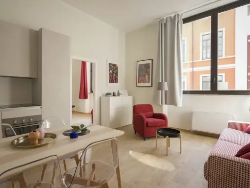 Modernes Wohnzimmer mit Essbereich. Klare Linien und helle Farben prägen die verschiedenen style richtungen. Rote Akzente setzen Akzente.