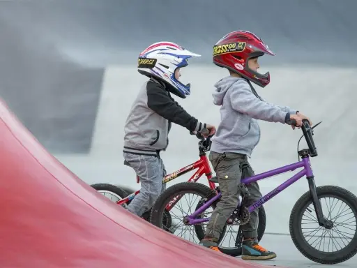 Dwóch chłopców w kaskach na rowerach BMX gotowych do zjazdu. Idealne rzeszów atrakcje dla dzieci do aktywnego spędzania czasu.