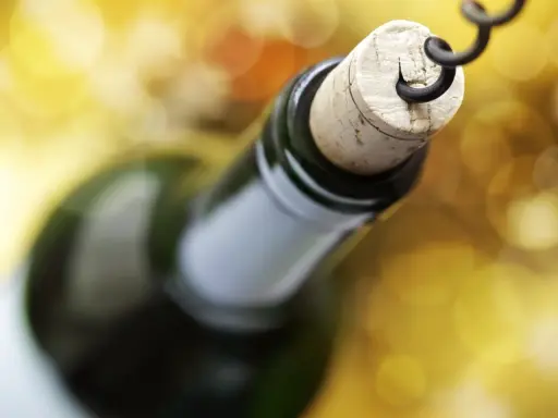 Korek wyciągany korkociągiem z butelki wina. Czyżby szykował się wieczór z alkoholem na poziomie 4 promile?