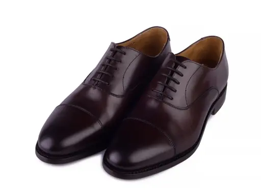 Eleganckie, brązowe buty angielskie marki, wykonane ze skóry, z klasycznym sznurowaniem i ozdobnym przeszyciem na nosku.