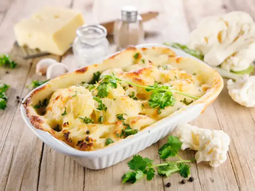 Un délicieux gratin de chou-fleur doré et gratiné, garni de persil frais, prêt à être dégusté.