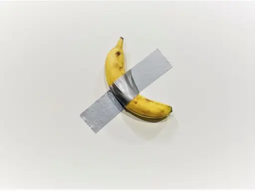 A ripe banana, a symbol of Maurizio Cattelan's art, is taped to a white wall.