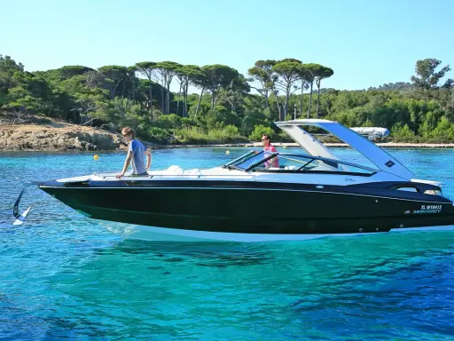 L'ancre du bateau est prête à être jetée dans les eaux turquoise. Deux hommes profitent d'une journée ensoleillée sur leur yacht.