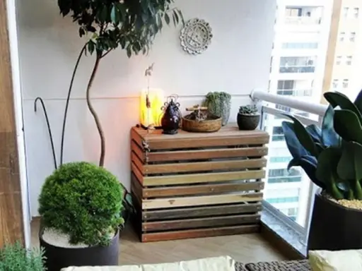 Mueble de madera para camuflar aire acondicionado exterior, decorado con plantas y objetos.