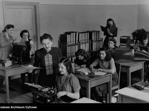 Kobiety pracujące w biurze, jedna przy maszynie do pisania, inne nad dokumentami. To właśnie tajne komplety, czyli tajne nauczanie, które odbywało się w ukryciu.