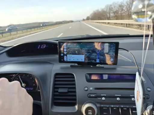 Na ekranie w samochodzie widać nawigację z funkcją co to jest carplay. Pokazuje trasę, odległość i czas dojazdu.