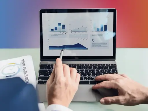 Ręce analizują wykresy na laptopie, przygotowując materiały do seo bloga.