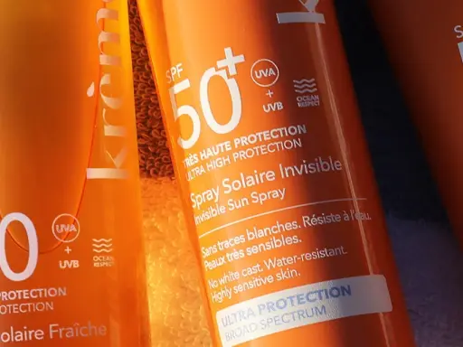 Trois tubes de crème solaire, tous avec SPF 50, prêts pour la protection solaire. L'un est un spray invisible, l'autre un lait hydratant.