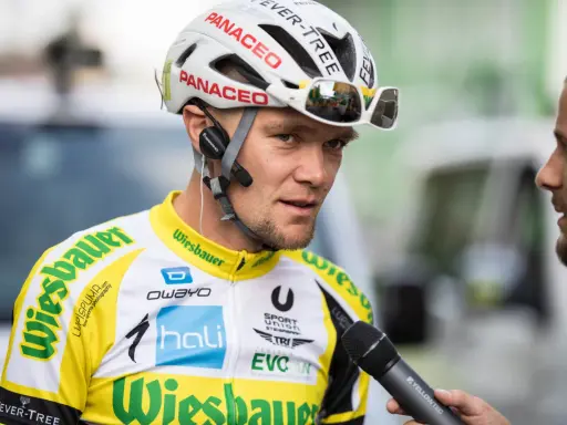 Radsportler mit Helm und Mikrofon, bereit für ein Interview nach einem harten Rennen, vielleicht dem Race Across America.
