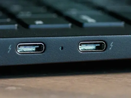 Dwa porty Thunderbolt 4 na obudowie laptopa, gotowe do szybkiego transferu danych i ładowania.