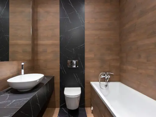 Baño moderno con lavabo ovalado, bañera y un inodoro con salida vertical o horizontal, todo rodeado de azulejos de madera y mármol negro.