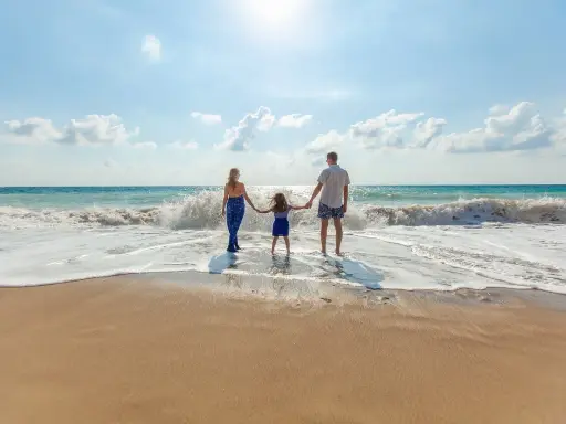 Familia disfrutando de un día en la playa de Altea con niños, jugando entre las olas.