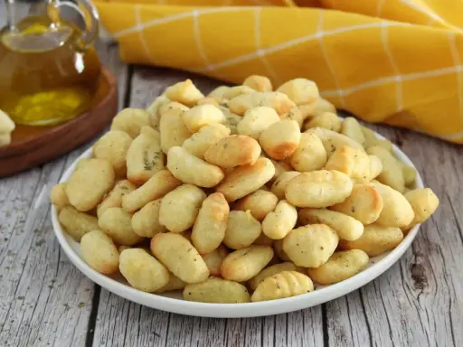 Gnocchi dorati e croccanti, preparati in friggitrice ad aria, conditi con erbe aromatiche.