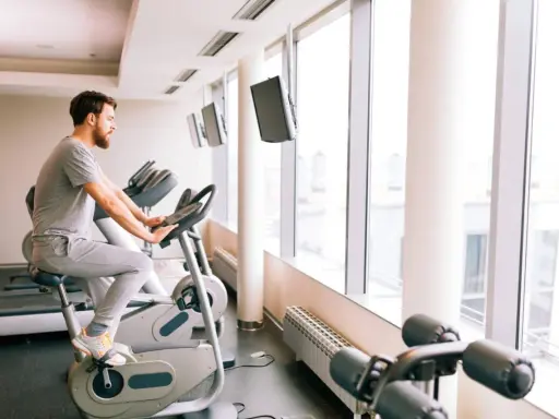Mężczyzna ćwiczy na rowerze stacjonarnym, który może być dobrym wyborem, jeśli zastanawiasz się, jaki rower stacjonarny do rehabilitacji kolana wybrać.