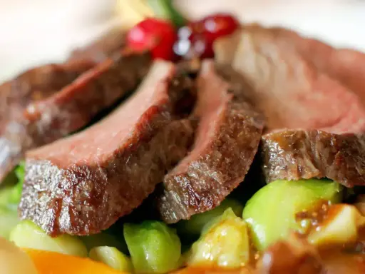 Saftiges Wildfleisch, zart geschnitten, mit knackigem Gemüse und Beeren garniert. Eine köstliche Antwort auf die Frage: Ist Wildfleisch gesund?