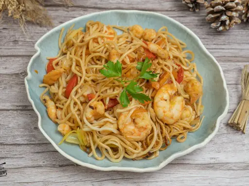 Delicioso plato de noodles con gambas, pimientos rojos y perejil fresco. Un festín para los sentidos.
