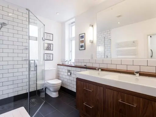 Baños modernos y reformados con plato de ducha, lavabo doble y mueble de madera.