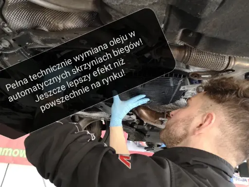 Mechanik w niebieskiej rękawiczce dokonuje wymiany oleju w automatycznej skrzyni biegów, zapewniając lepszy efekt niż standardowe rozwiązania.