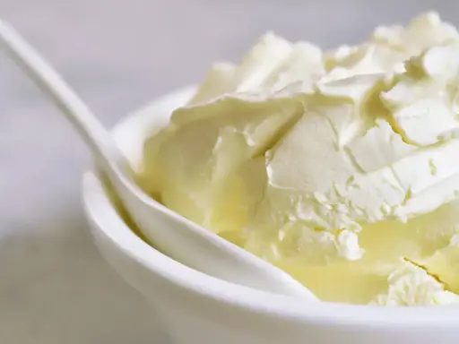 Kremowa masa w miseczce, idealna jako zamiennik mascarpone do deserów.