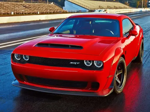 Czerwony Dodge Challenger Demon na torze wyścigowym, gotowy do startu.