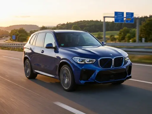 Blauer BMW iX5 Elektro fährt auf der Autobahn bei Sonnenuntergang.