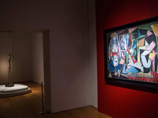 A museum gallery showcases Picasso's "Les Femmes d'Alger" alongside a slender bronze sculpture.