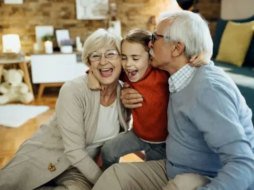 Nonna e nonno abbracciano felici la nipote. Un momento di gioia che sottolinea il diritto dei nonni a vedere i nipoti, un legame prezioso.