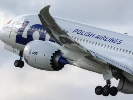 Samolot LOT Polish Airlines w locie, widok z boku na silnik i skrzydło.