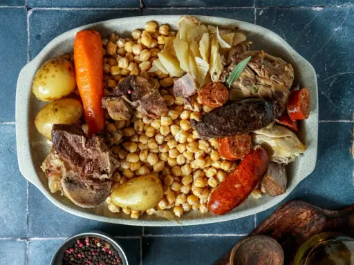 Un plato generoso para comer cocido en pueblos de Madrid: garbanzos, patatas, zanahoria, carnes y embutidos.