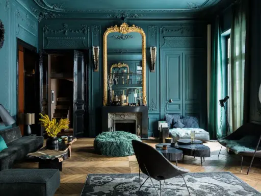 Elegancja w kolorze petrol blue: salon z bogatymi zdobieniami, złotym lustrem i nowoczesnymi meblami.