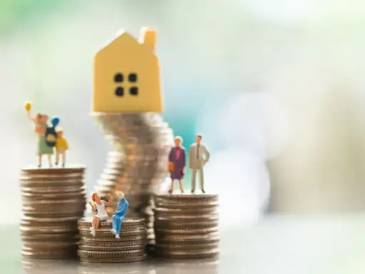 Miniaturowe figurki ludzi i domku na stosach monet. Symbolizują różne modele rodziny, w tym rodzinę patchworkową, i ich sytuację finansową.