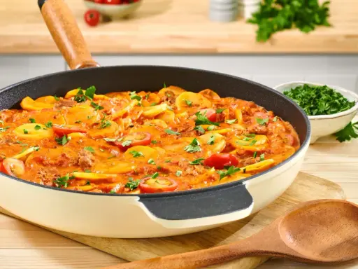 Herzhaftes rezept hackfleisch kartoffeln in einer Pfanne, garniert mit Petersilie und Kirschtomaten.