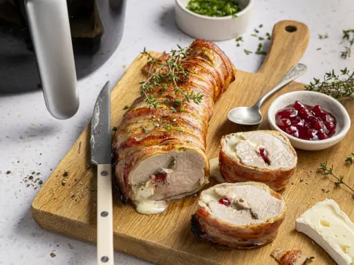 Saftiges schweinefilet im speckmantel, perfekt im Airfryer zubereitet, mit Käse und Cranberry-Füllung.