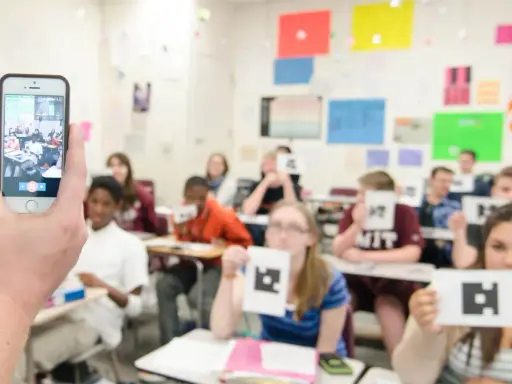 Classe che usa un'app per la scuola, con studenti che mostrano carte con simboli.