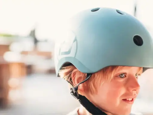 Chłopiec w jasnoniebieskim kasku rowerowym, gotowy na przygodę.
