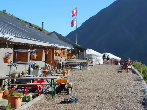 Górskie schronisko, idealne na przerwę podczas tour de Mont Blanc. Dwa rowery, szwajcarskie flagi i piękne widoki.
