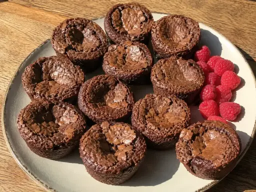 En tallrik med kladdkakemuffins och hallon. Perfekt för ett kladdkakemuffins recept!