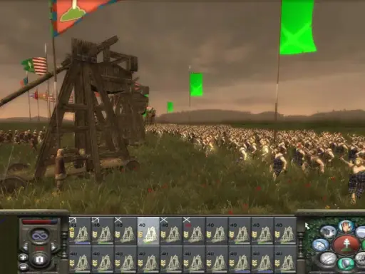 Bitwa w grze strategicznej, przypominającej gry podobne do Total War. Ogromna armia w starożytnych strojach, machiny oblężnicze i flagi na tle pochmurnego nieba.