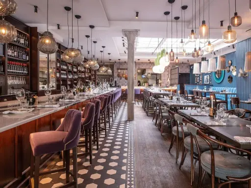 Elegant restaurang med bardisk, sammetsstolar och vackra lampor. Perfekt för en trevlig kväll, som många **sorellina recensioner** vittnar om.