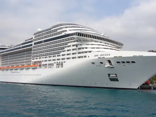 MSC Divina attracca in porto. Immagina il comfort delle msc divina cabine interne, un rifugio accogliente dopo una giornata di esplorazione.