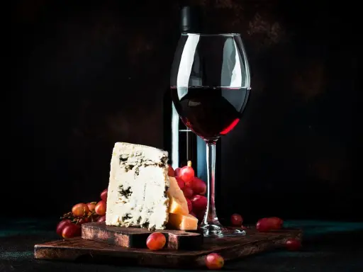 Ein Glas Rotwein, Käse und Trauben. Was ist Portwein? Ein süßer, aufgespriteter Wein, der oft zu Käse serviert wird.