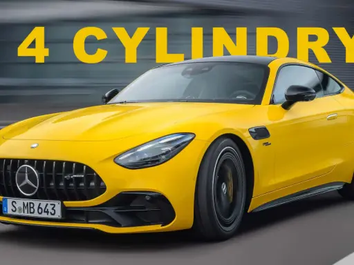 Żółty Mercedes-AMG GT 43 z napisem "4 CYLINDY" na tle szarego, rozmazanego tła.