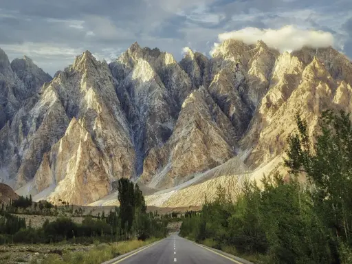 Droga w Karakorum Highway prowadzi przez surowe, skaliste góry oświetlone słońcem.