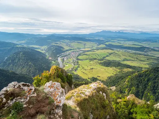 Widok z góry na dolinę z rzeką i miasteczkiem, w oddali majaczą Tatry. Trzy Korony w pełnej krasie.