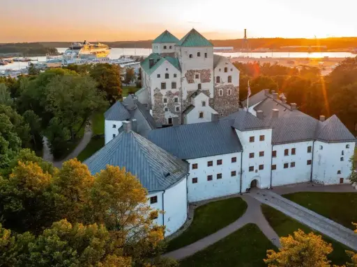 Zamek w Turku, jeden z głównych punktów, turku co zobaczyć, o zachodzie słońca. W tle port z wycieczkowcem.