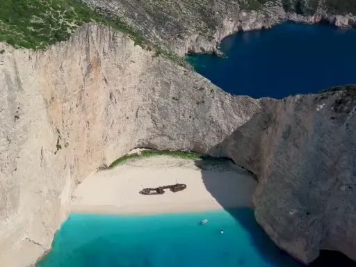 Navagio, jedna z najpiękniejszych plaż Zakynthos, z wrakiem statku na białym piasku i turkusową wodą.