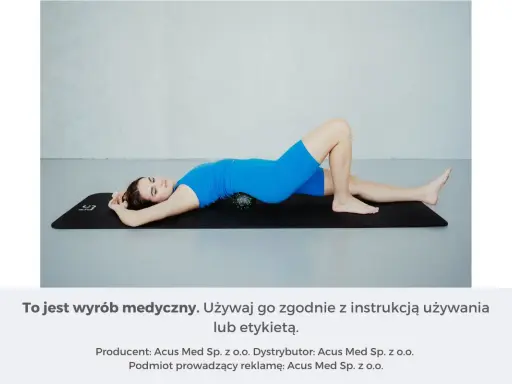 Kobieta leży na macie z piłką do masażu pod plecami. Dowiedz się, jak używać piłki do masażu dla ulgi.