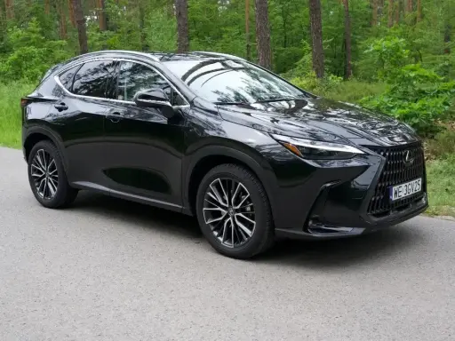 Lśniący czarny Lexus NX 2025 na tle zielonego lasu. Elegancki SUV gotowy na przygodę.
